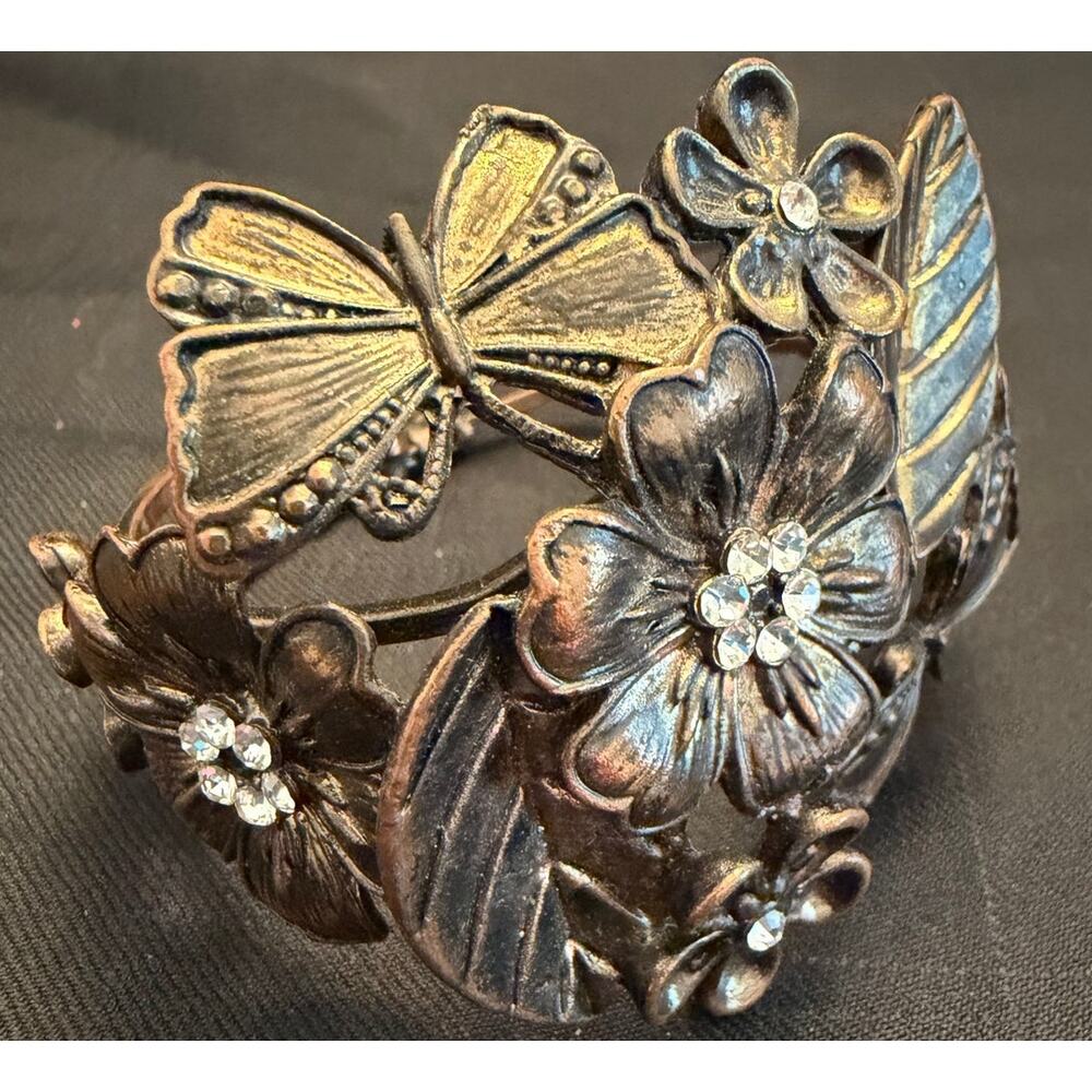 1990s vintage hinged cuff bracelet a floral and butterfly motif, antiqued-brass